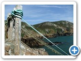 The rope posts and coastline behind